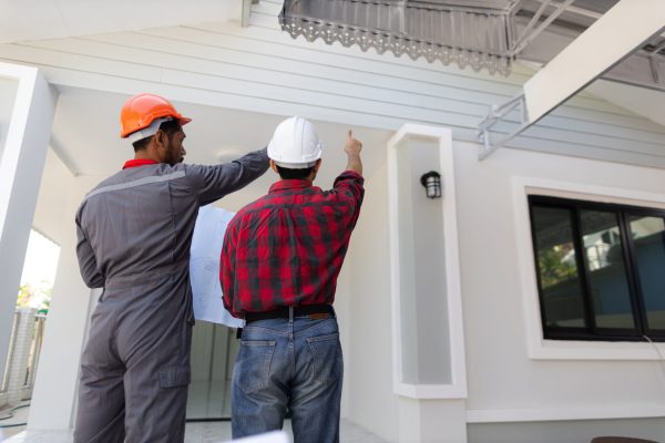 Contractor engineer discusses with an architect the construction of a home renovation project at the job site.
